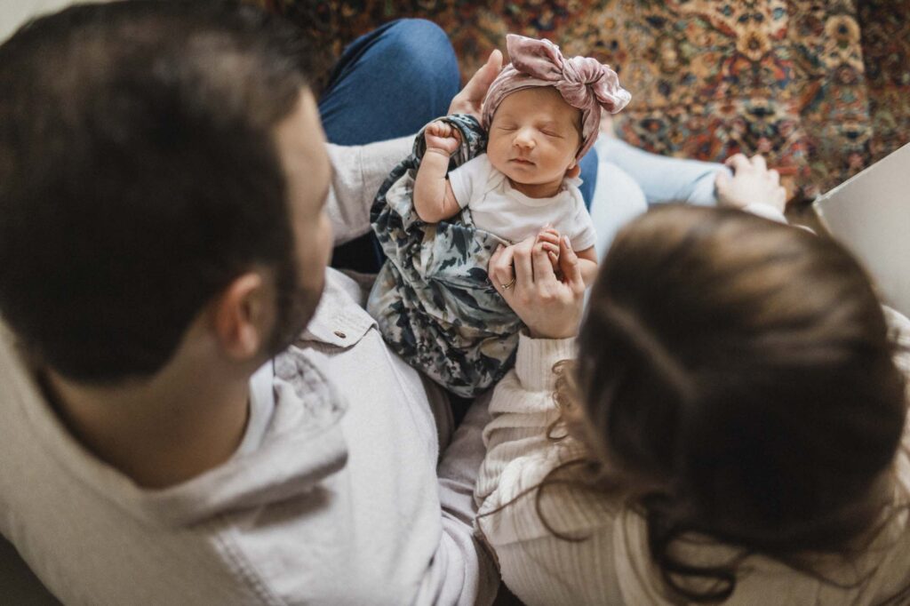 Mom and dad holding baby during newborn photo session