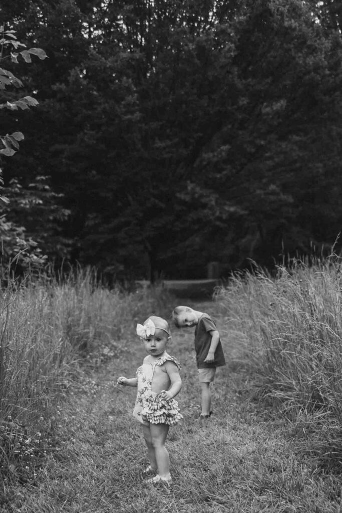 Brother and sister on grassy path during family photoshoot
