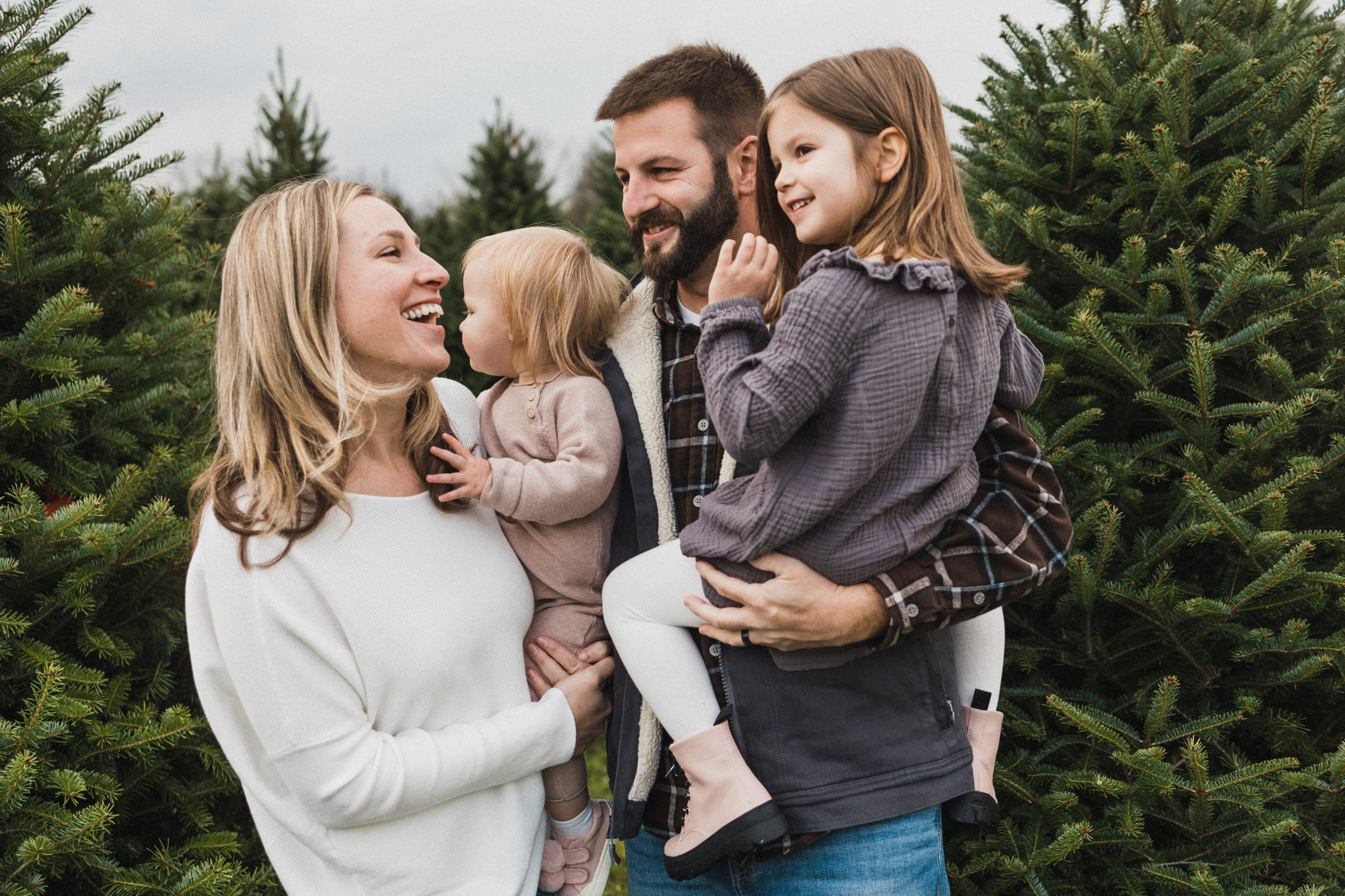 Family of four laughing at Christmas tree farm in Cleveland, OH