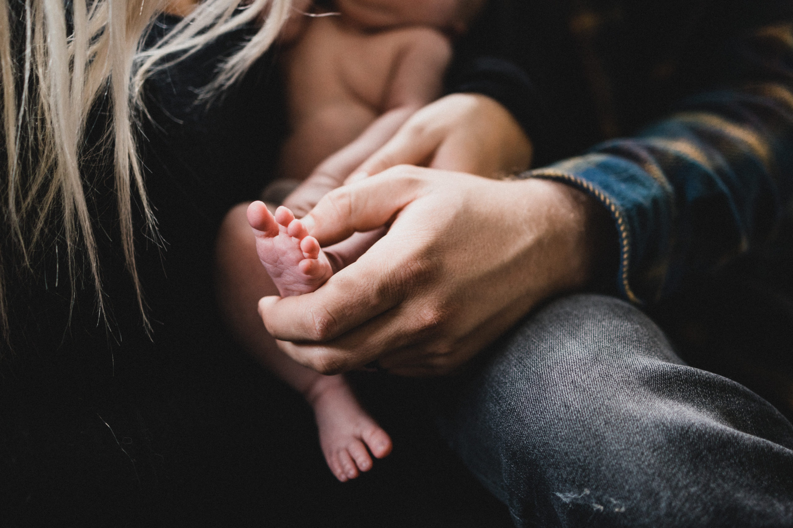 Dad holding baby's toes during an in-home newborn session