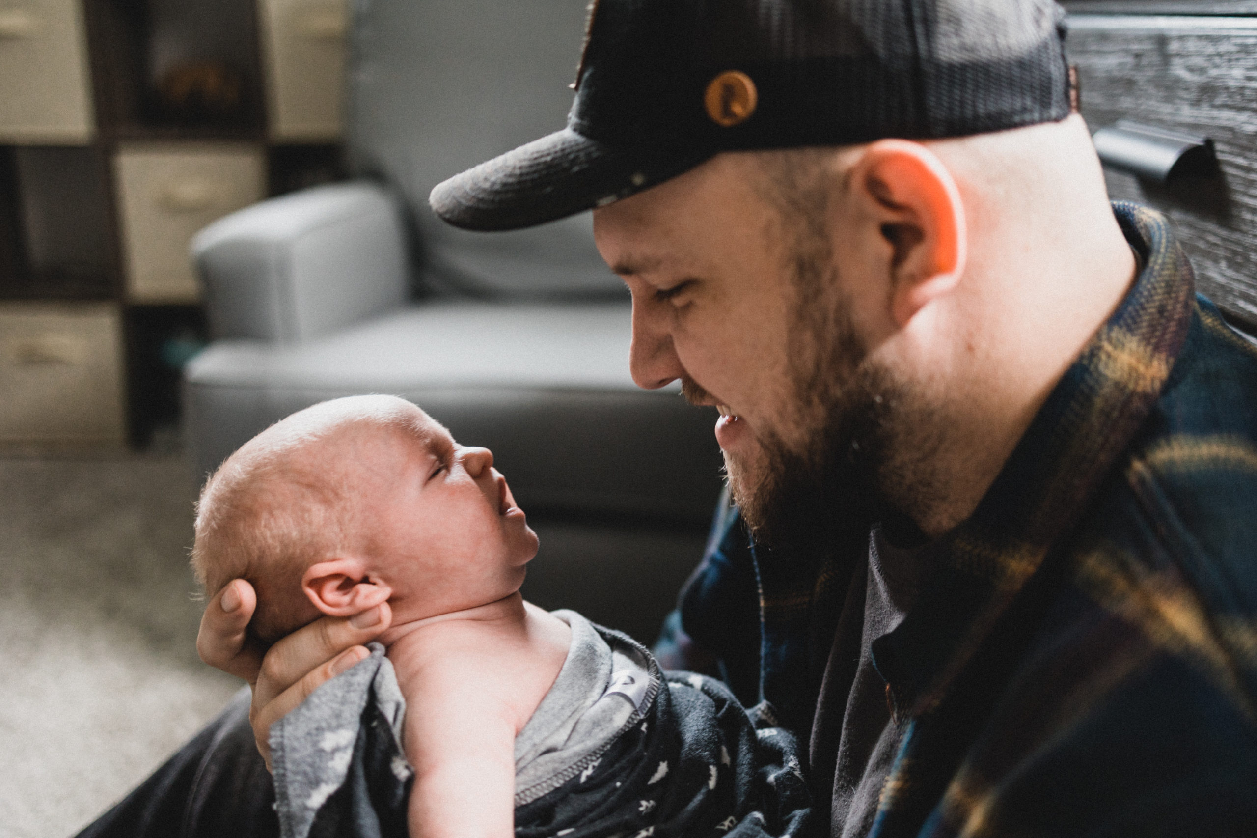 Dad looking at newborn son in nursery during and in-home newborn session
