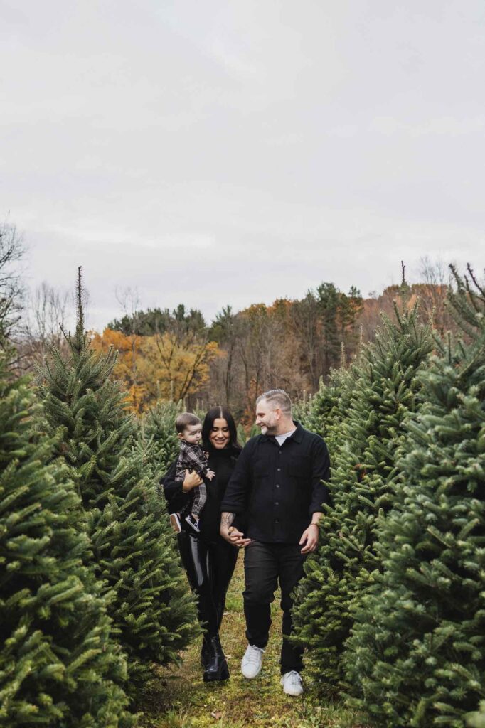 Mom, dad and son walking through Christmas trees at Sugar Pines in Cleveland, OH
