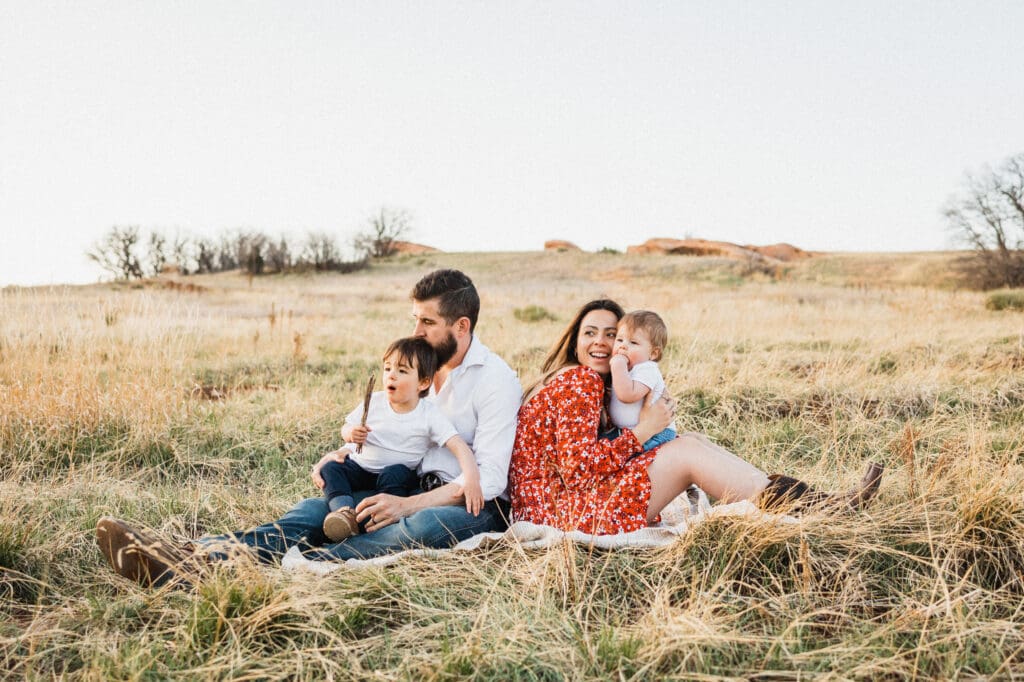 Mom, dad and sons in meadow during family photography session
