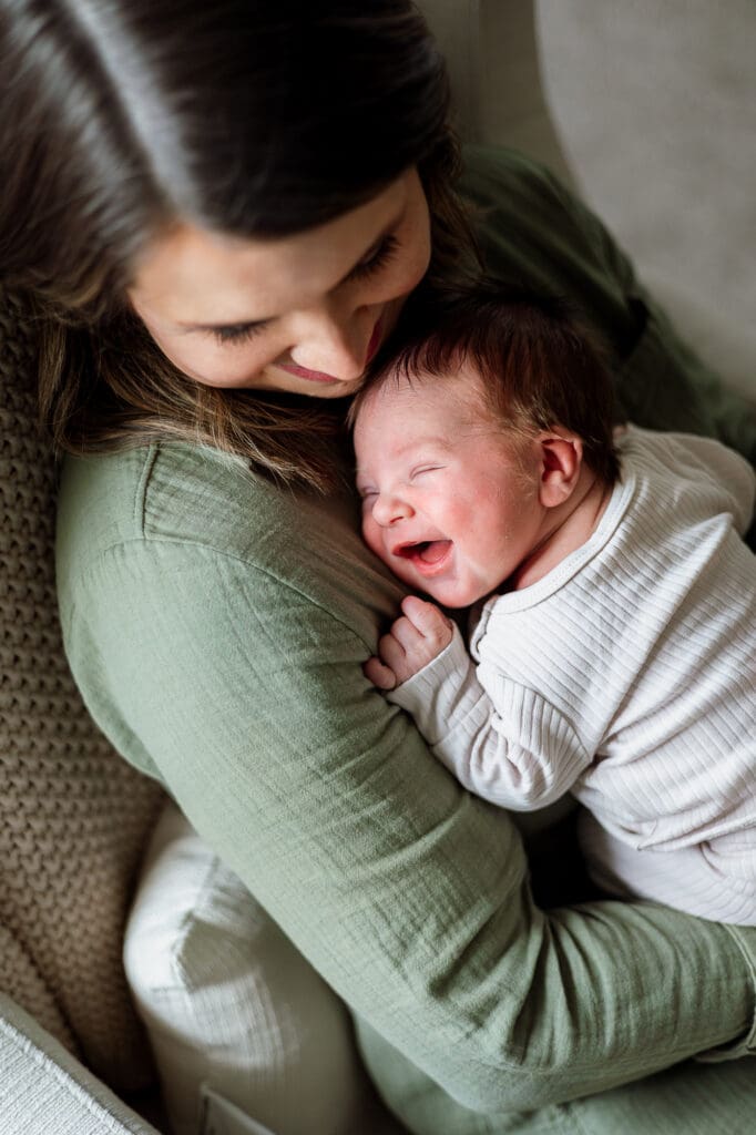 Mom in rocker with smiling newborn during Chagrin Falls newborn photography session
