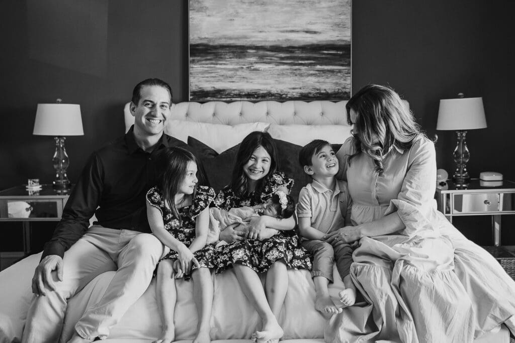 Family of six sitting on bed during Cleveland newborn photography session