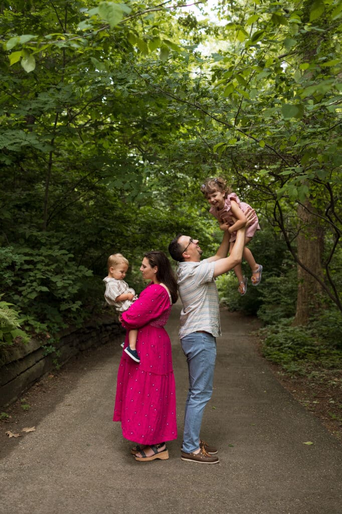 Mom holding son and dad tossing daughter in the air at Cleveland Botanical Garden family photo session