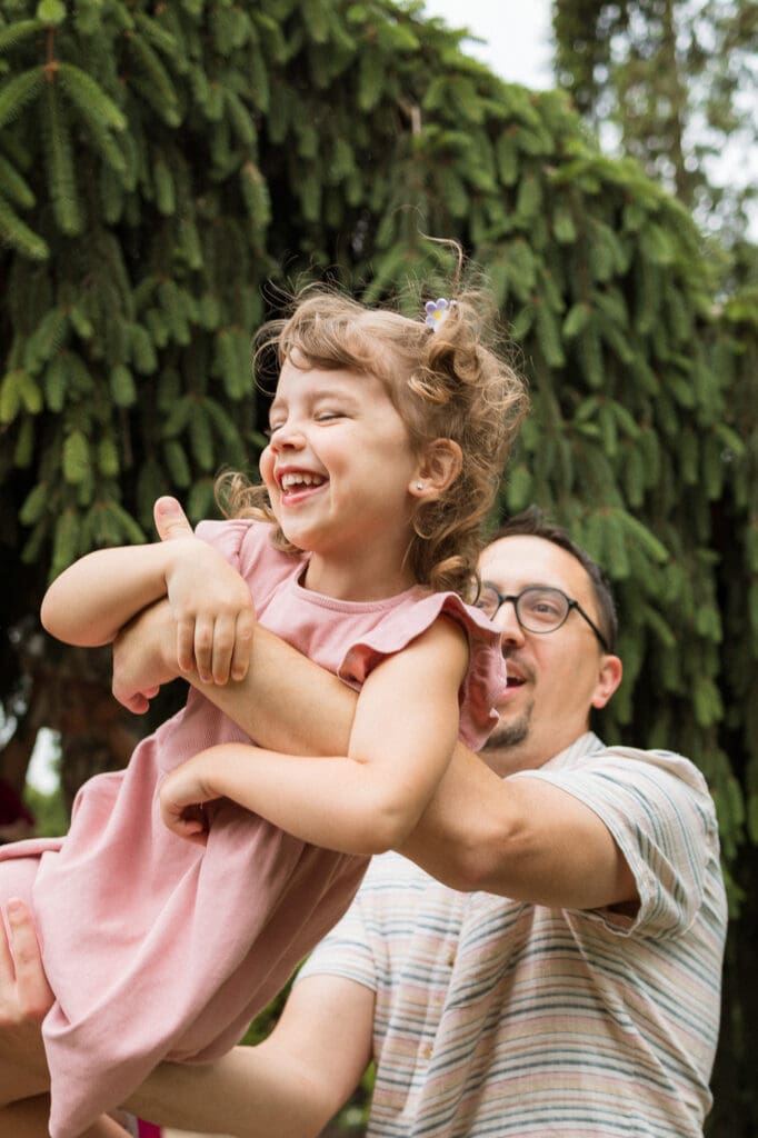 Dad tossing little girl in the air during family photo session in Cleveland
