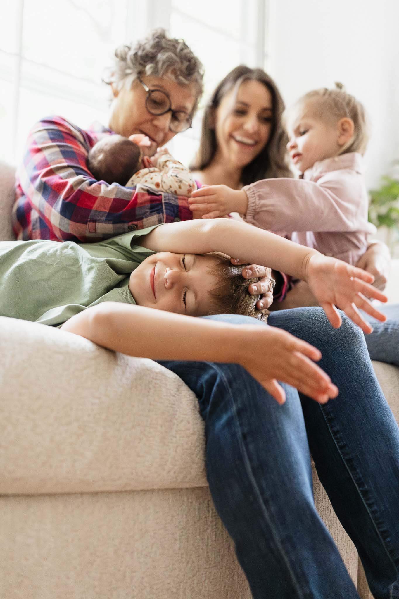 Generational family snuggling on couch during in-home family photography session in Cleveland.