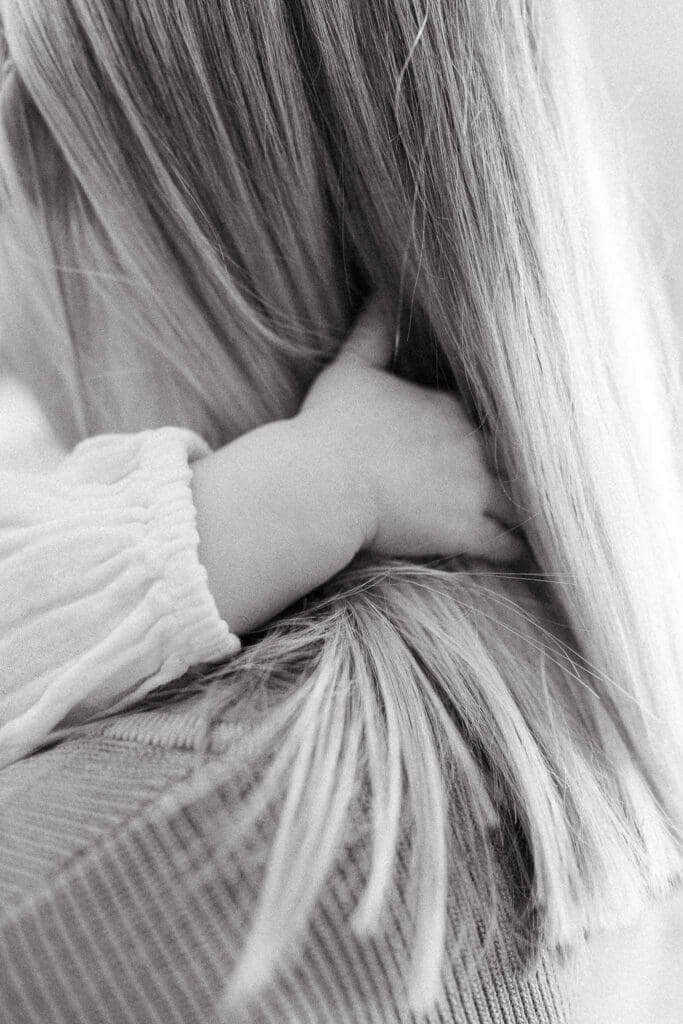 Baby's hands in mom's hair during a quiet moment. 