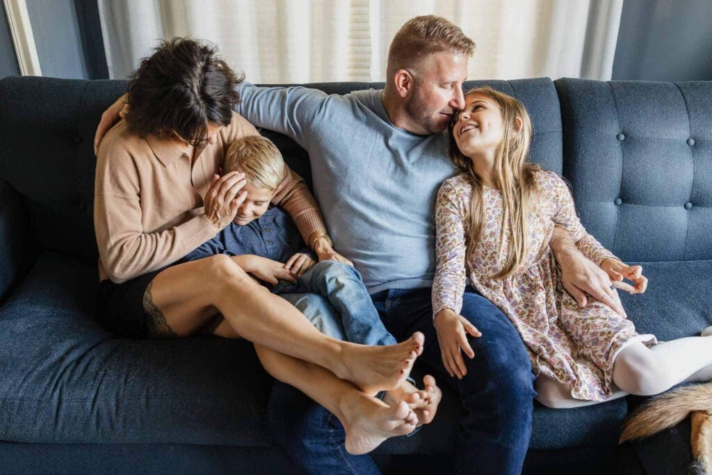 Family of four on blue couch during Cleveland Heights in-home family photos.