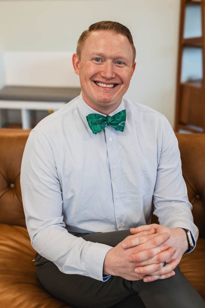 Dr. Mike Perisa, a smiling pediatrician at Zest Pediatrics in Cleveland, OH, sitting in his office, providing direct pediatric care to local families.