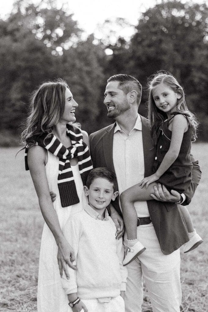 Family laughing in a field during fall golden hour photoshoot.