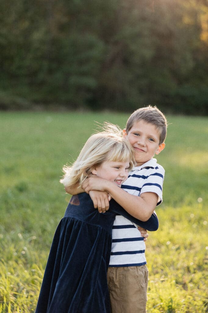 Siblings hugging in field during fall golden hour photoshoot in Cleveland, O
H.