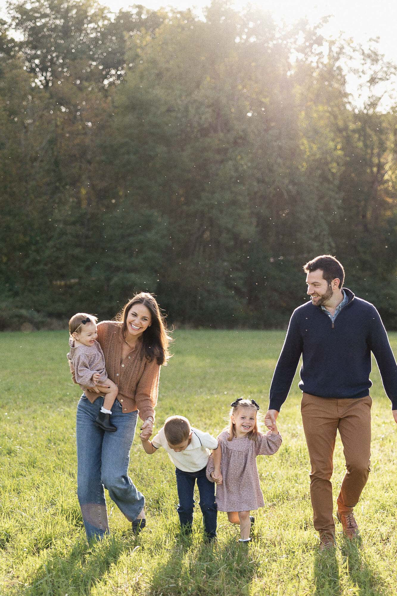 Family walking in a field during a golden hour photoshoot in Cleveland, OH.